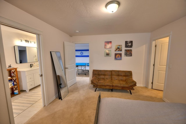 living area featuring light carpet, baseboards, and a textured ceiling