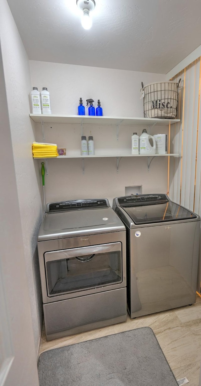 clothes washing area with light wood-style floors and washing machine and clothes dryer