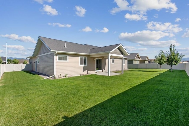 back of house featuring a yard, a patio, and a fenced backyard