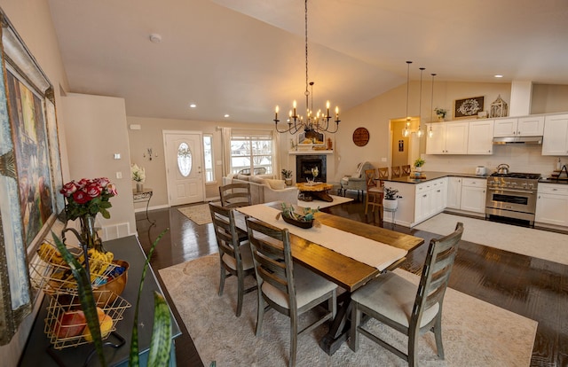 dining area featuring lofted ceiling, recessed lighting, dark wood-style flooring, a fireplace, and baseboards