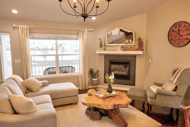 living room with recessed lighting, a tiled fireplace, an inviting chandelier, wood finished floors, and baseboards