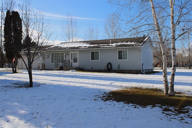 view of snow covered back of property