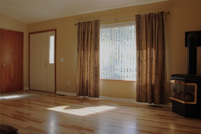 15 Sully Rd, Plains, MT 59859 - unfurnished living room featuring a wood stove, healthy amount of natural light, and hardwood / wood-style floors