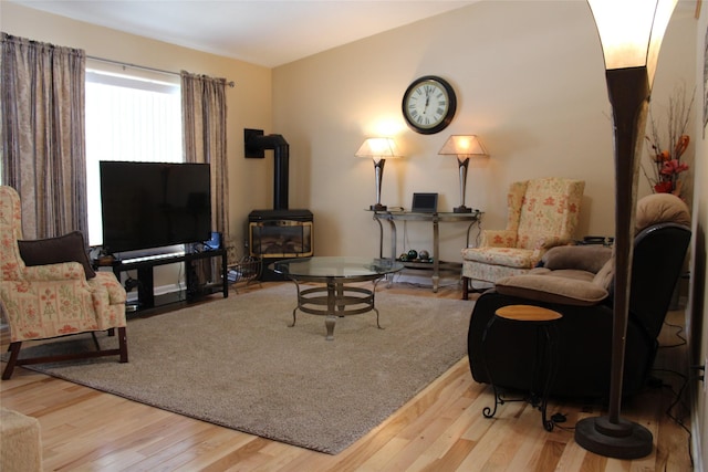 living room with a wood stove and light wood-type flooring