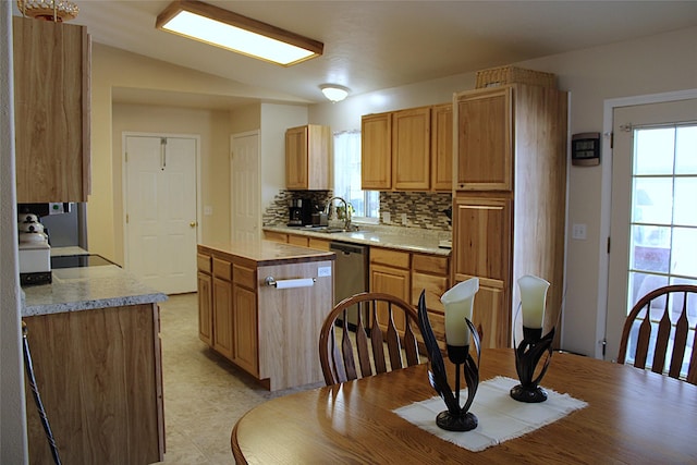 kitchen with tasteful backsplash, vaulted ceiling, sink, dishwasher, and plenty of natural light