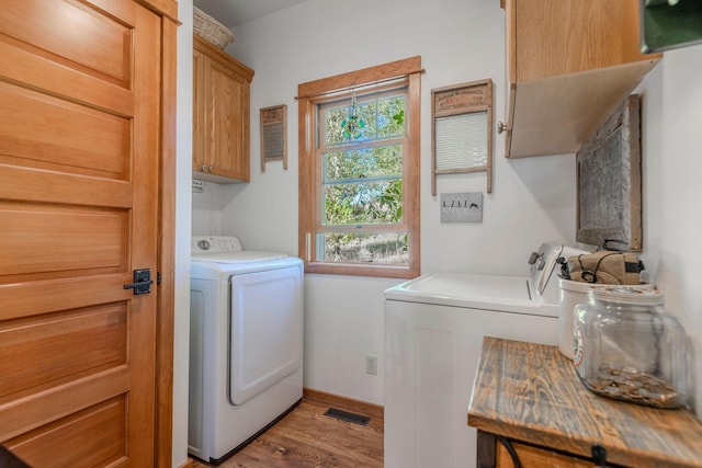 washroom with light hardwood / wood-style floors, cabinets, and independent washer and dryer