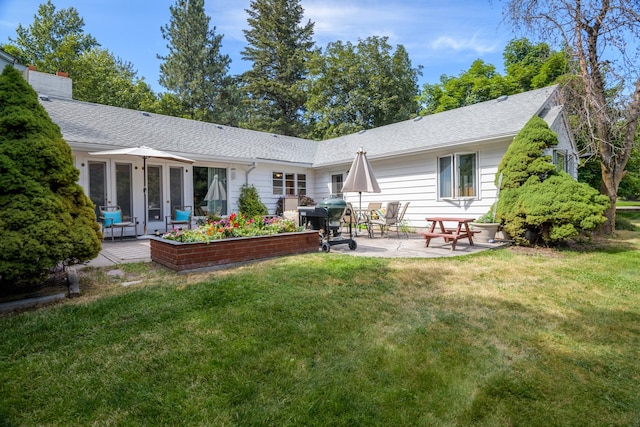 rear view of house featuring a patio area and a yard