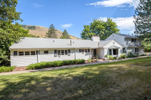 view of front of property with a mountain view and a front lawn