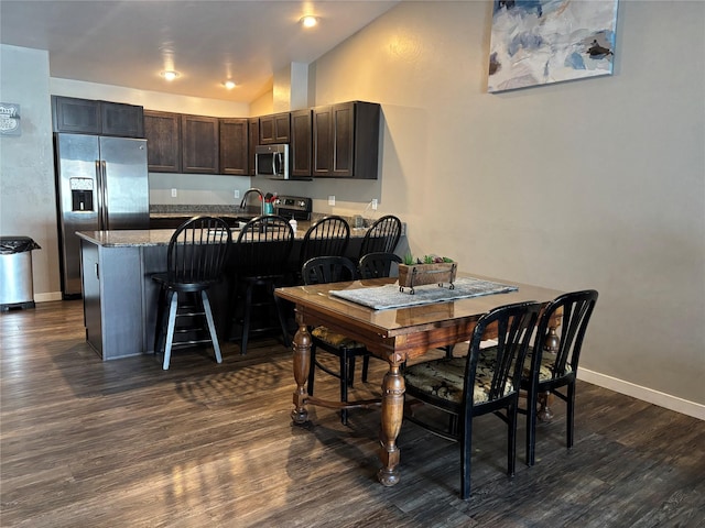 dining space featuring dark hardwood / wood-style flooring and lofted ceiling