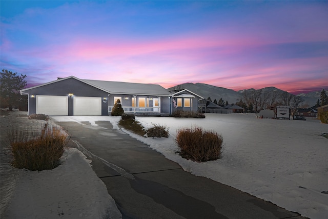 single story home with a mountain view, a garage, and covered porch