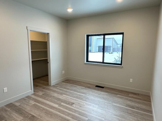 3416 Goldenrod Ln, Kalispell, MT 59901 - unfurnished bedroom with a spacious closet, light wood-style flooring, a closet, and recessed lighting