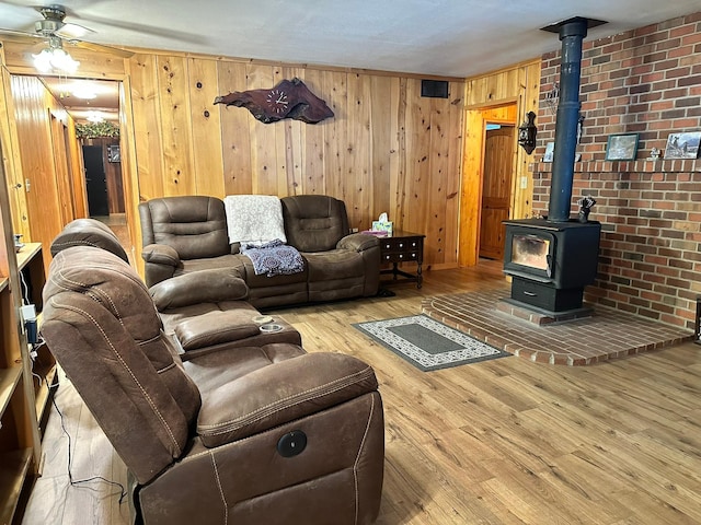 27 Birch Ln, Trout Creek, MT 59874 - living room featuring a wood stove, wooden walls, a ceiling fan, and wood finished floors