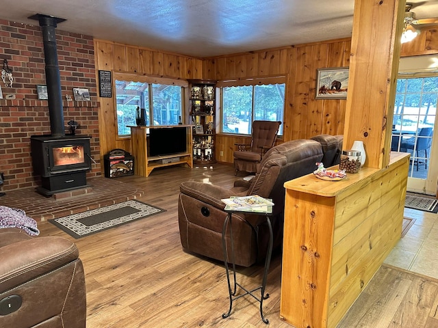 27 Birch Ln, Trout Creek, MT 59874 - living area with a wood stove, wood finished floors, wooden walls, and ceiling fan