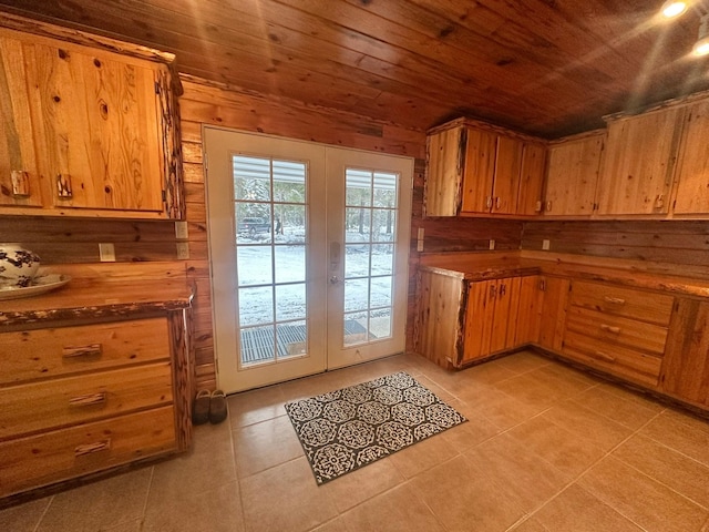 27 Birch Ln, Trout Creek, MT 59874 - kitchen with french doors, light tile patterned floors, wood ceiling, wooden walls, and brown cabinets