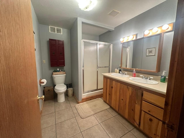 bathroom with tile patterned flooring, vanity, an enclosed shower, and toilet