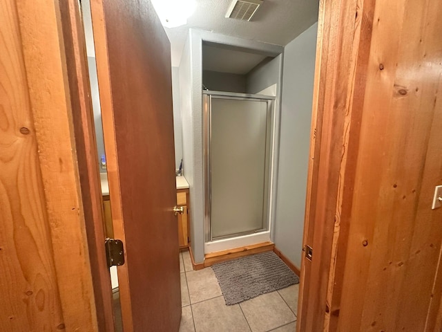 bathroom with tile patterned floors and walk in shower