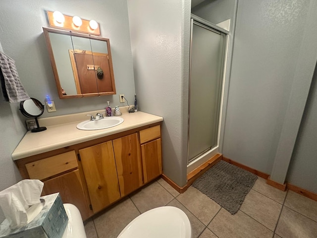 bathroom with tile patterned floors, toilet, vanity, and walk in shower