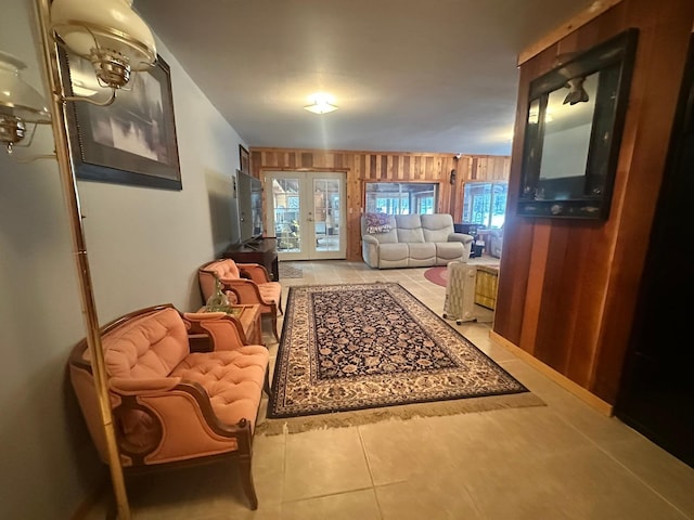 tiled living room featuring french doors and wooden walls