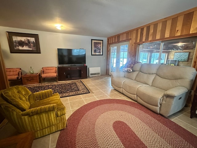 tiled living room with wood walls and french doors