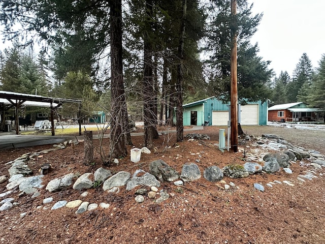 view of yard featuring a garage and an outdoor structure