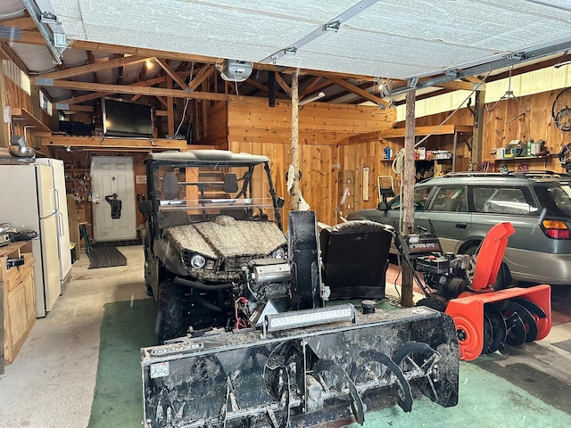 27 Birch Ln, Trout Creek, MT 59874 - garage with freestanding refrigerator, wood walls, and a garage door opener