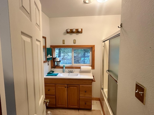 bathroom with tile patterned floors, vanity, and enclosed tub / shower combo