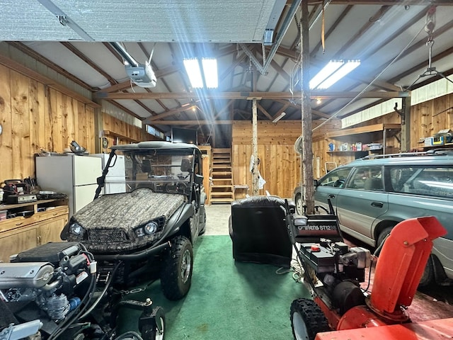 garage featuring wood walls, white fridge, and a garage door opener