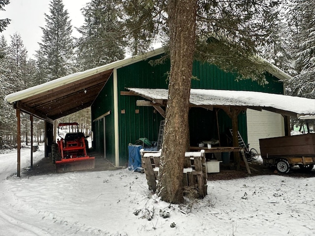 snow covered parking area featuring a carport