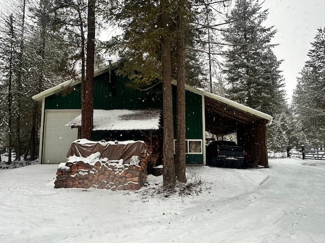 view of snow covered exterior featuring a garage and a carport