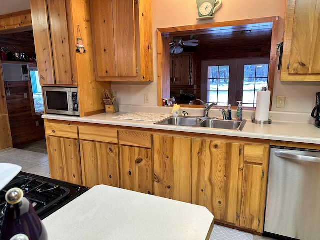 kitchen with ceiling fan, sink, french doors, and appliances with stainless steel finishes