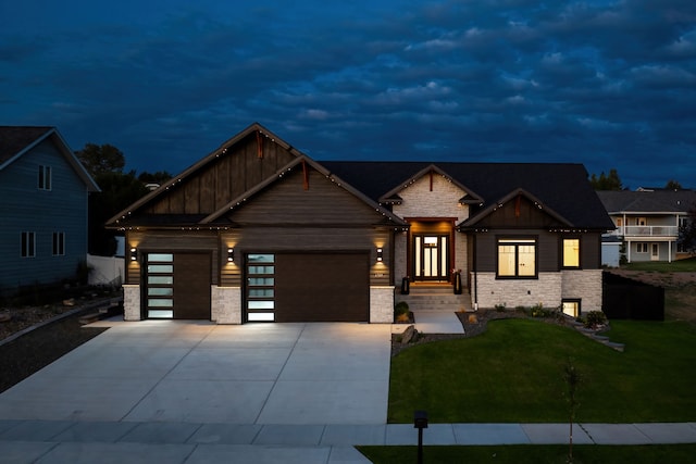 craftsman inspired home featuring a garage and a lawn