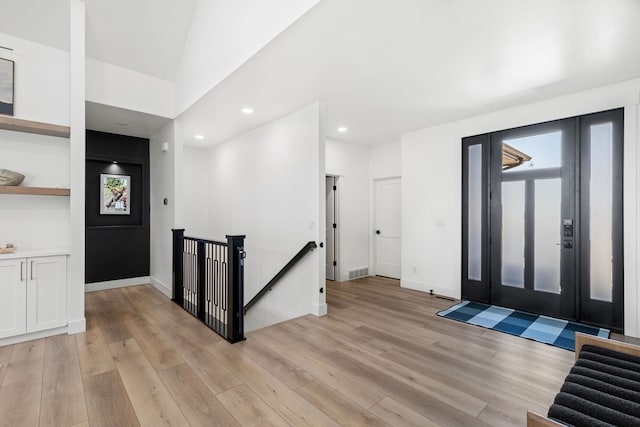 entrance foyer with lofted ceiling and light wood-type flooring