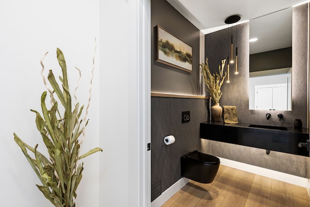 bathroom with toilet, sink, and hardwood / wood-style flooring