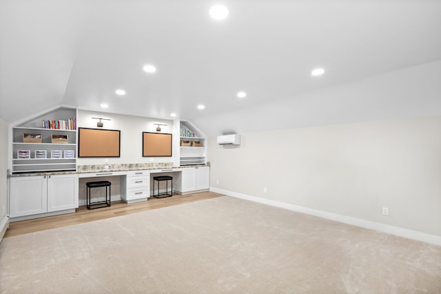 unfurnished living room featuring built in shelves, light hardwood / wood-style floors, and vaulted ceiling