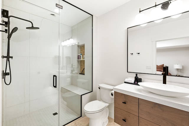 bathroom with toilet, vanity, and walk in shower