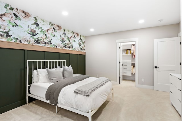 carpeted bedroom featuring a spacious closet and a closet