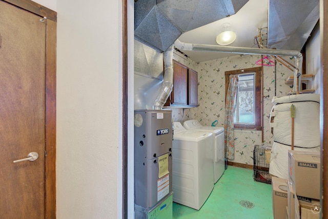 clothes washing area with washer and dryer and cabinets