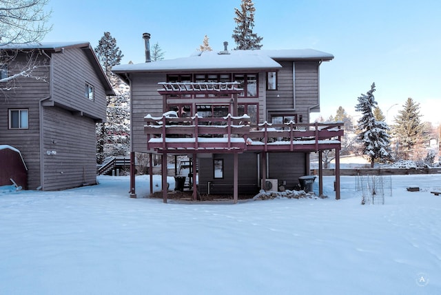 snow covered house with a wooden deck