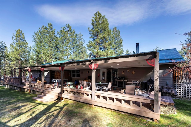 rear view of house with a yard and a wooden deck