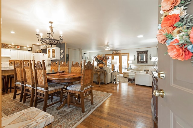 dining space with dark hardwood / wood-style floors and ceiling fan with notable chandelier