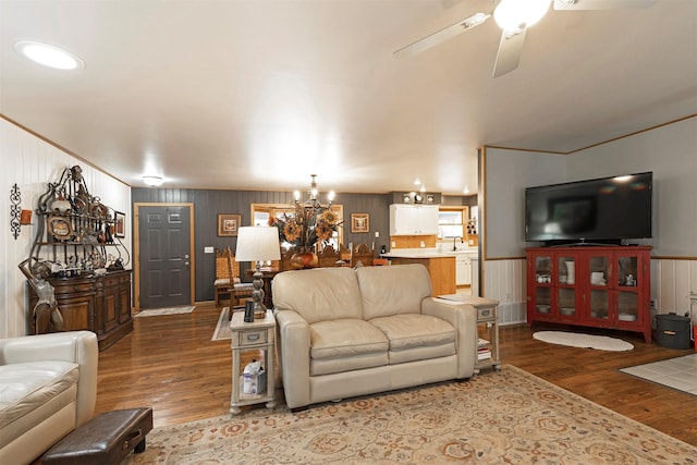 living room featuring sink, wood-type flooring, and ceiling fan with notable chandelier