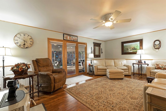 living room with ceiling fan, crown molding, and dark wood-type flooring