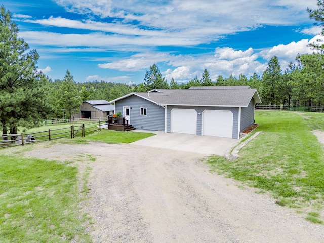 view of front facade featuring a garage, an outdoor structure, and a front lawn