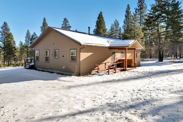 view of snow covered rear of property