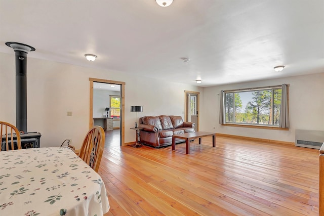 dining area with wood-type flooring and a wood stove