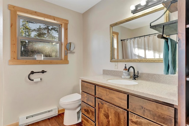 bathroom with wood-type flooring, vanity, toilet, and baseboard heating