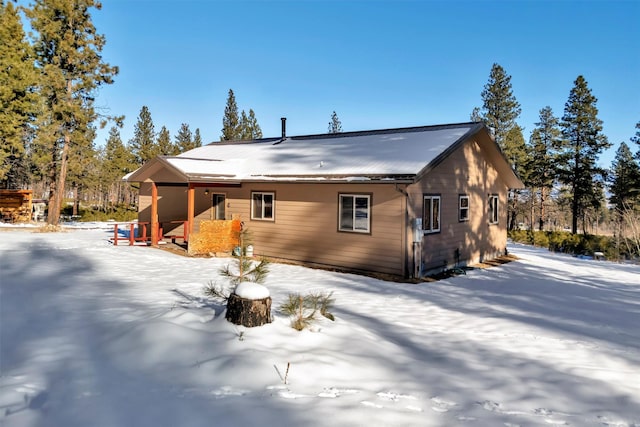 view of snow covered back of property