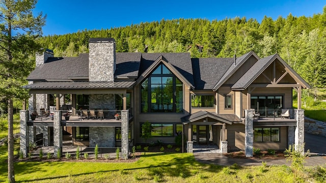 back of property featuring a yard, a balcony, and a patio area