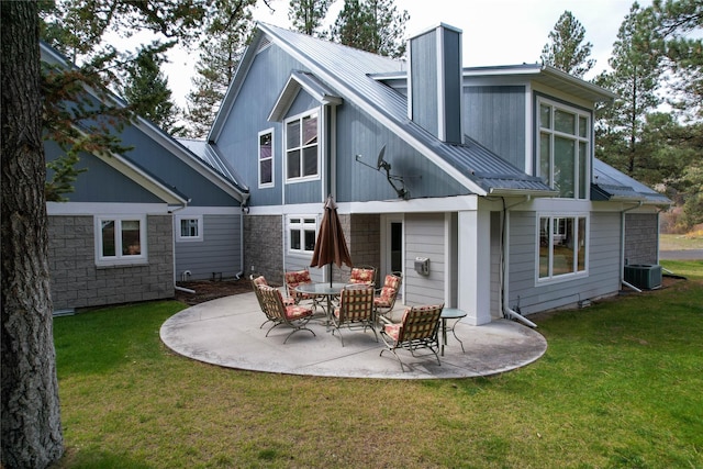 rear view of house with central AC, a patio area, and a lawn