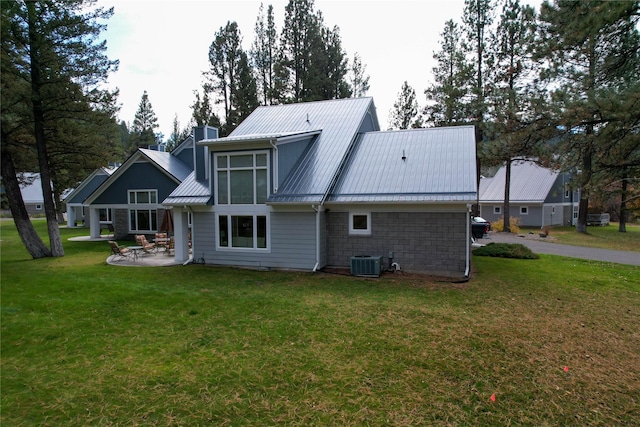 rear view of property featuring a lawn, a patio area, and cooling unit